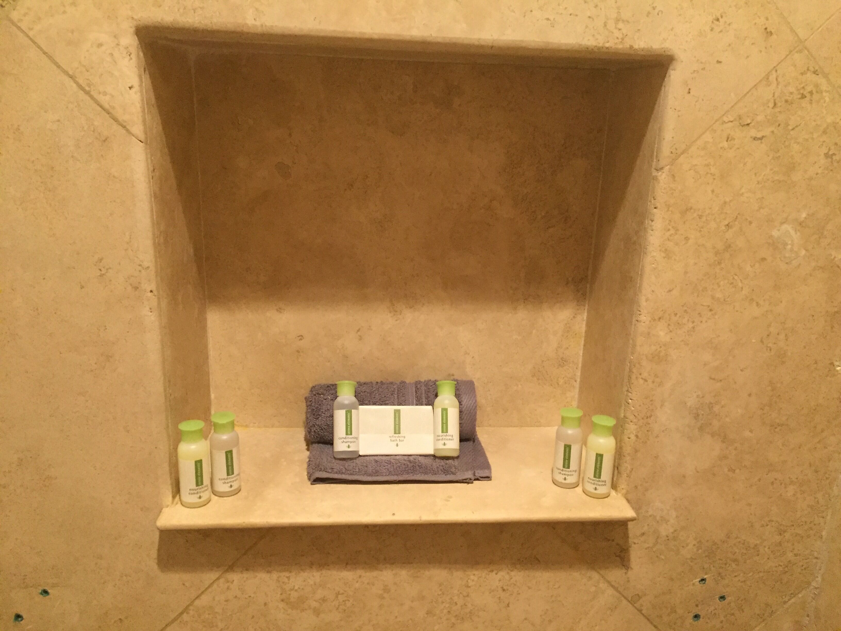 Ein Badezimmer mit Ablagefläche für Kosmetikartikel und einem Handtuch.