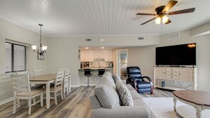 A spacious living room with a gray sofa, a wooden coffee table, and a ceiling fan. - Newly Renovated 2BR/2BA Flat/3 Smart TV’s/WIFI/Pool & Tennis/Pickleball Views (Hilton Head Island)