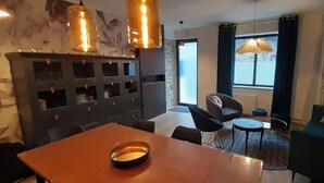 A modern living room with a dining table, chairs, a sofa, and a fireplace. - La Petite Bélérit, town house - Landerneau (Landerneau)