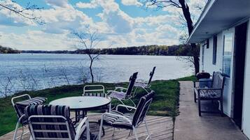 A deck with outdoor furniture overlooking a lake.