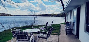 A deck with outdoor furniture overlooking a lake. - Charming 2-Bedroom Lakeside Cabin with Dock Access (Alexandria)