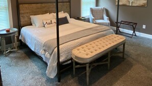A bedroom with a four-poster bed, a bench, a chair, and a painting on the wall. - Cozy Modern Cottage Style Home minutes from VT, RU, Christiansburg Aquatic Cente (Christiansburg)