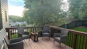 A wooden deck with wicker furniture and a view of a green landscape. - Cozy Modern Cottage Style Home minutes from VT, RU, Christiansburg Aquatic Cente (Christiansburg)