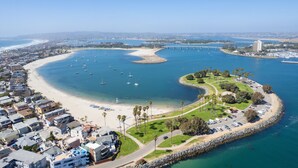 Vista aérea de una zona costera con playa, puerto deportivo y edificios residenciales.