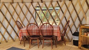 A dining area with a table set for four, wooden chairs, and a plaid tablecloth.