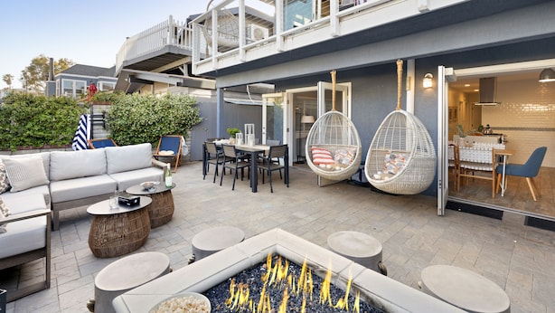 Eine moderne Außenpatio mit Feuerstelle, Sitzgruppe und Essbereich.