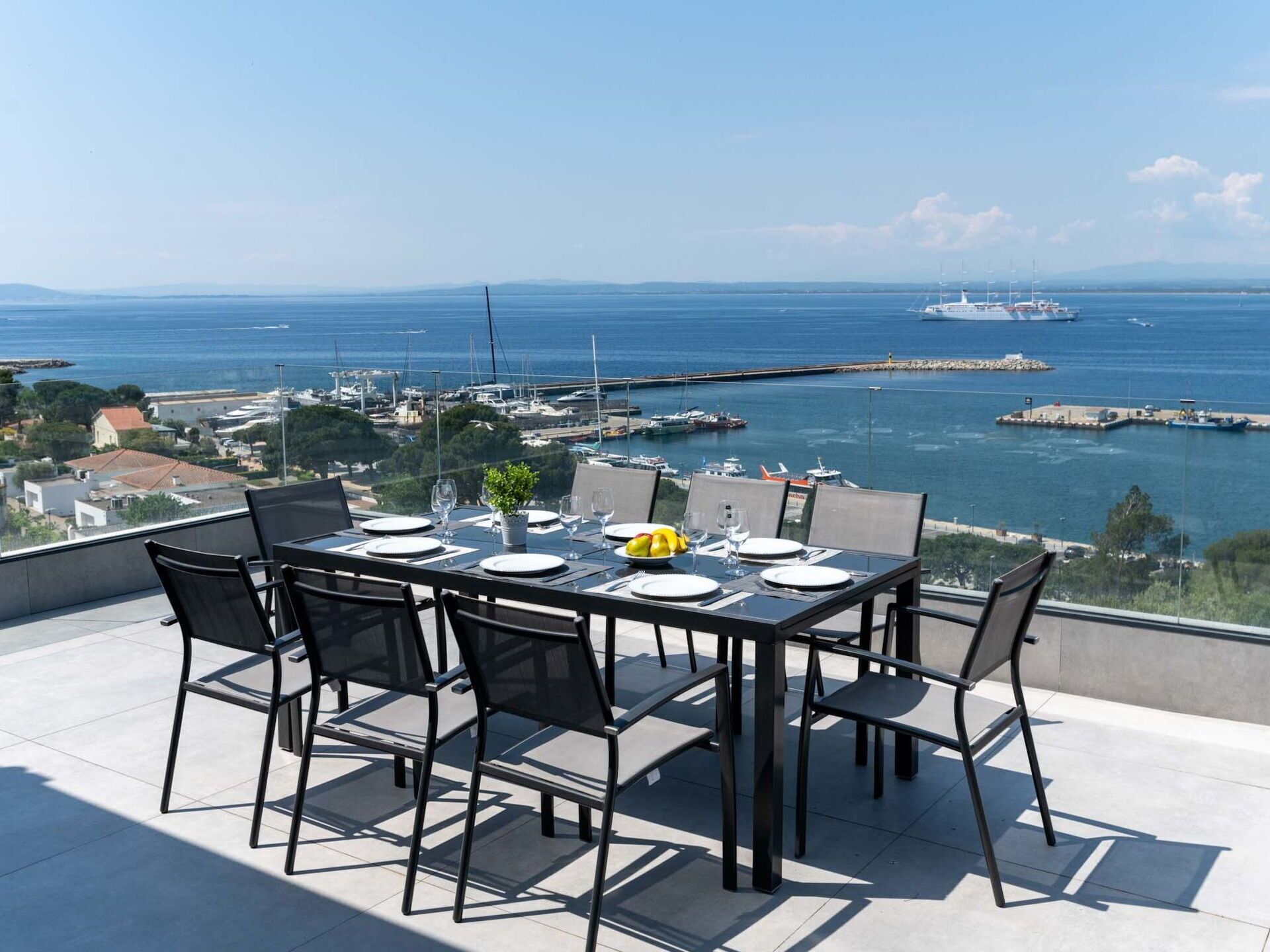 Een eettafel voor vier personen met uitzicht op zee en de jachthaven.