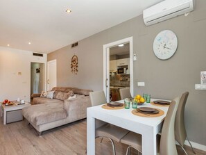 A modern apartment with a living area, kitchenette, and dining space.