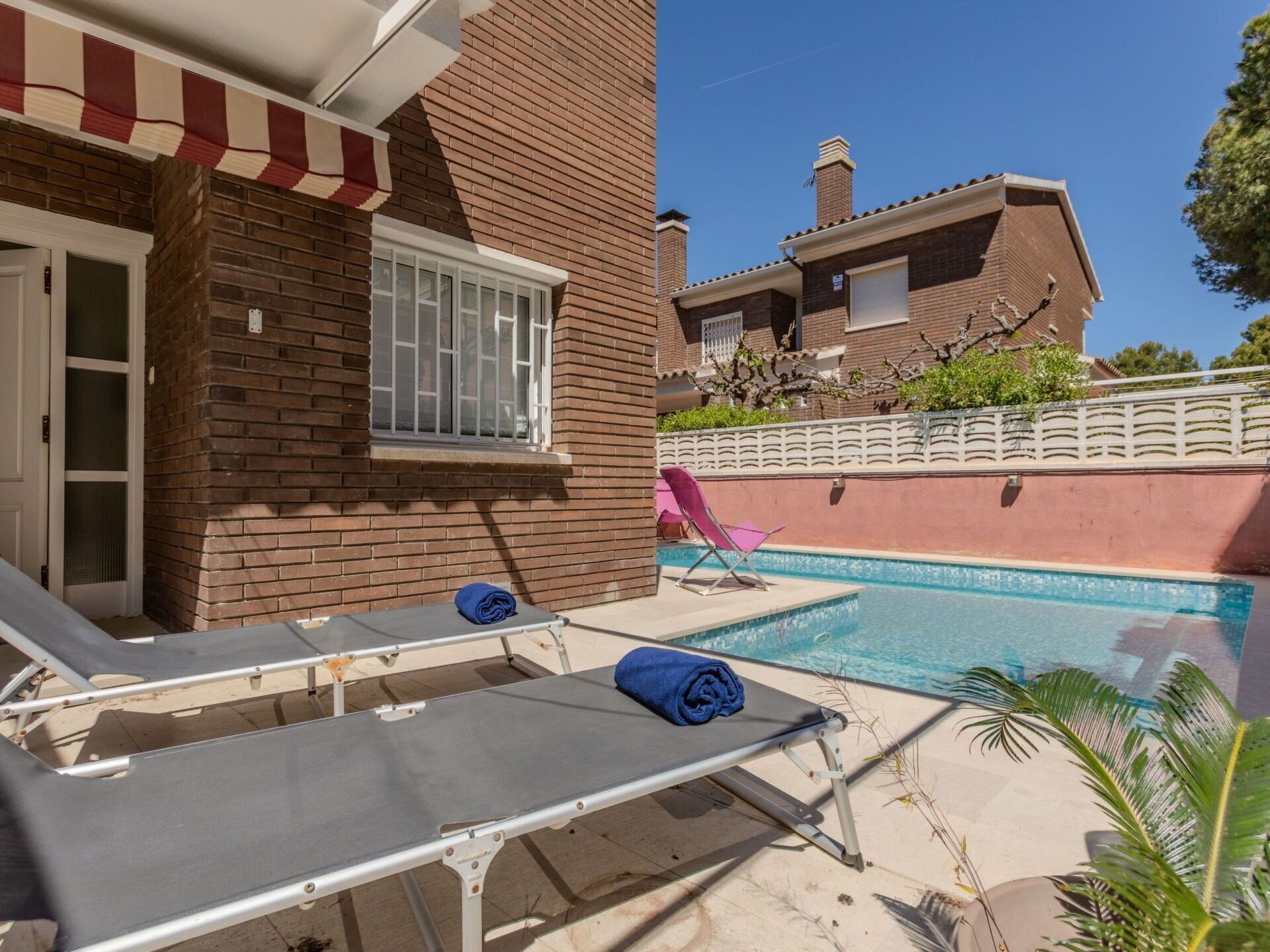 Un espace aménagé au bord de la piscine, avec des chaises longues et une petite piscine.