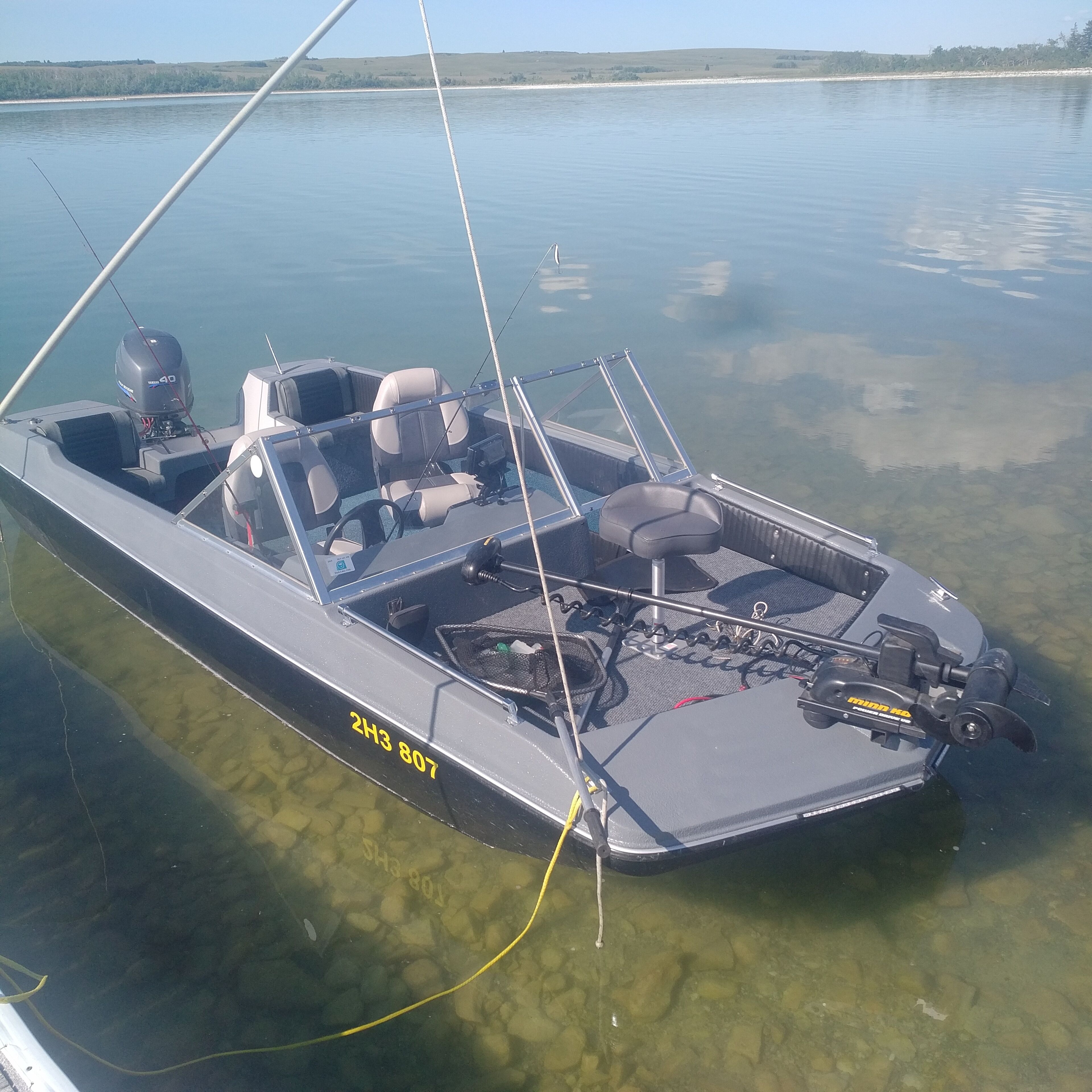 Um pequeno barco a motor com cabine, assentos e um motor com a inscrição '40'.