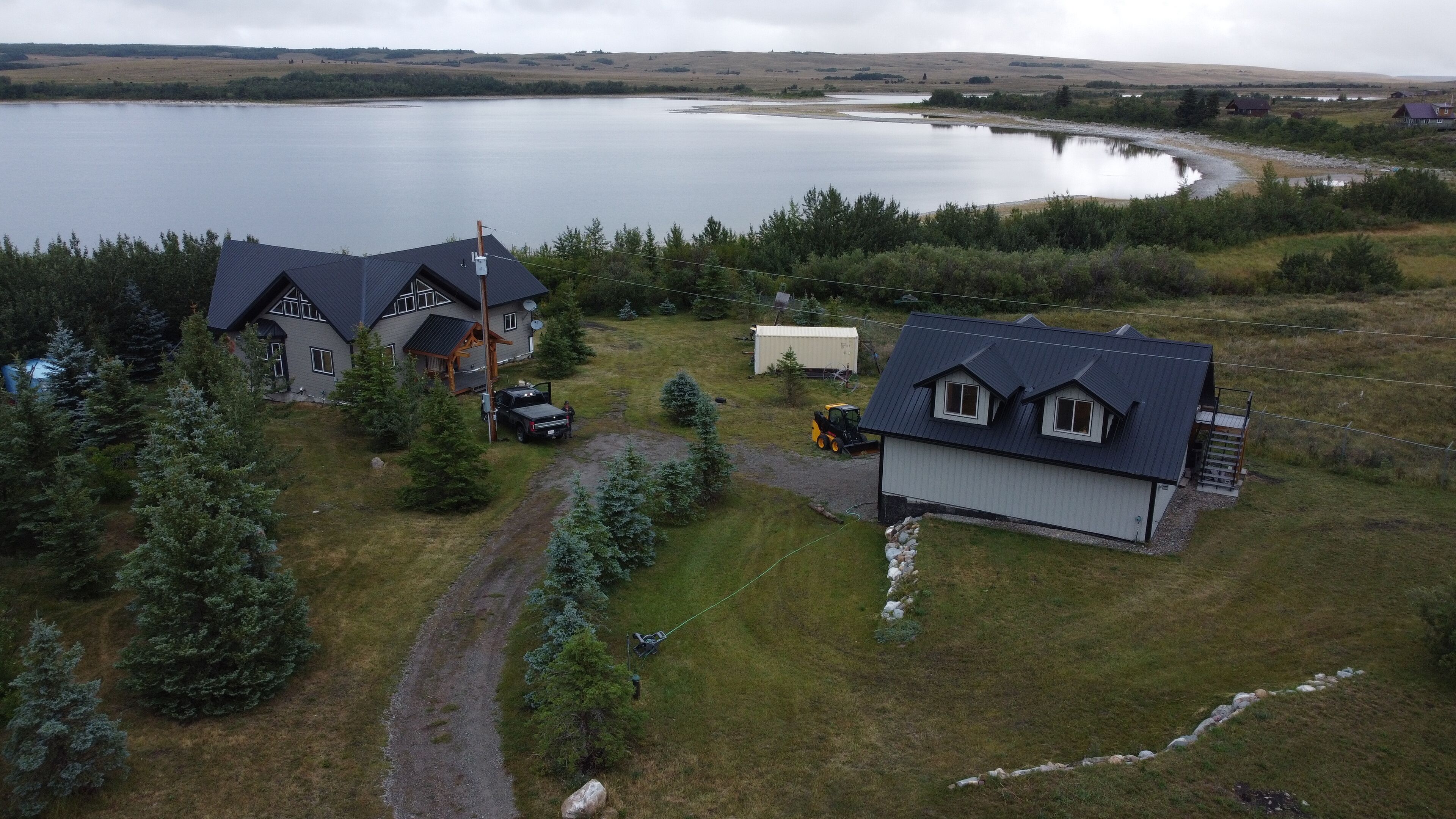 A large house with a garage, a driveway, and a small building.