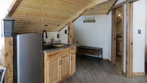 Une cuisine avec des meubles en bois, un plan de travail en granit et un réfrigérateur noir.