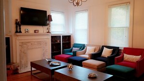 Ein Wohnzimmer mit Kamin, Fernseher und Bücherregal.