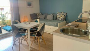 Een moderne woonruimte met een eethoek, kitchenette en zithoek.