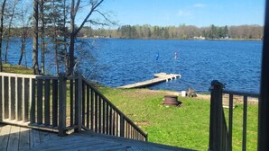 A wooden deck with a view of a lake and trees.