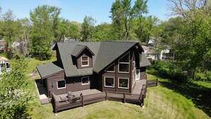 A two-story log cabin with a large deck and a wrap-around porch. - Cozy Log Cabin Near Indiana Dunes & Lake Michigan! (Portage)