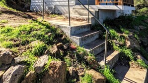 Una casa de una planta con un porche, un ventanal pequeño y una puerta.
