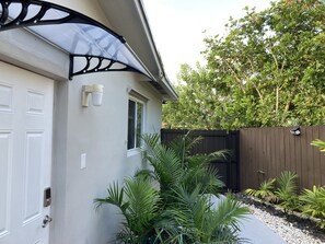 Une maison avec une porte de garage, une fenêtre et une clôture en bois.