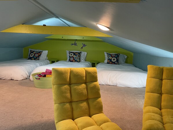 Een kamer met twee bedden, een groene wand en een geel plafond.