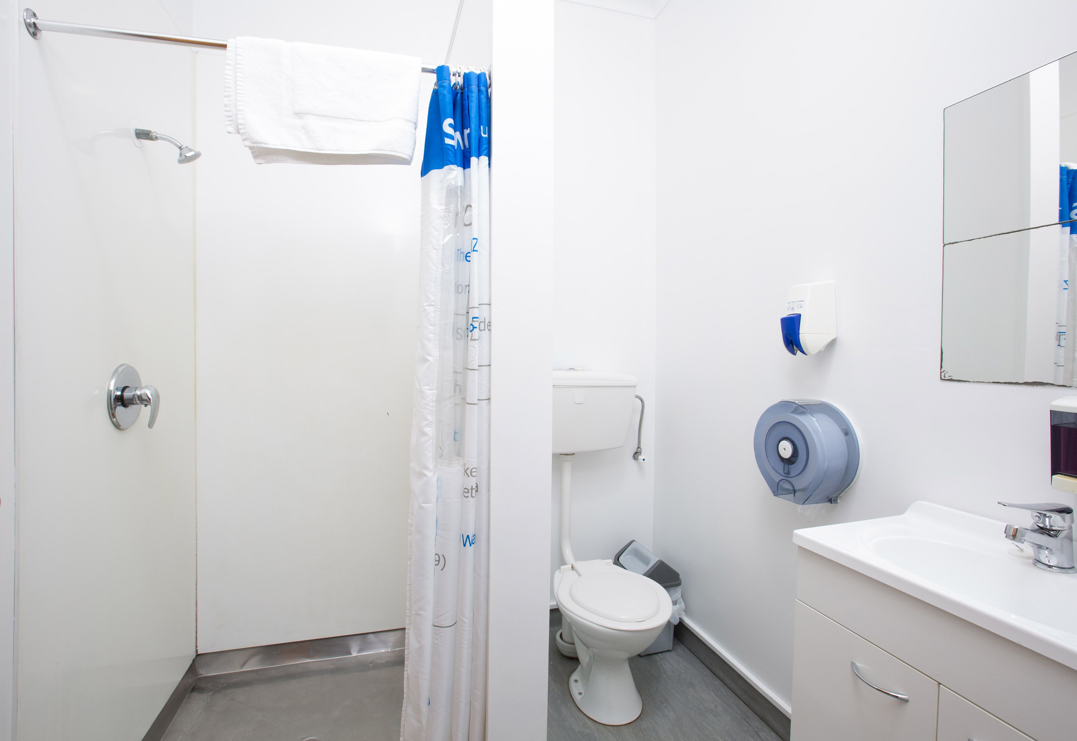 Ein Badezimmer mit Dusche, Toilette und Waschbecken.