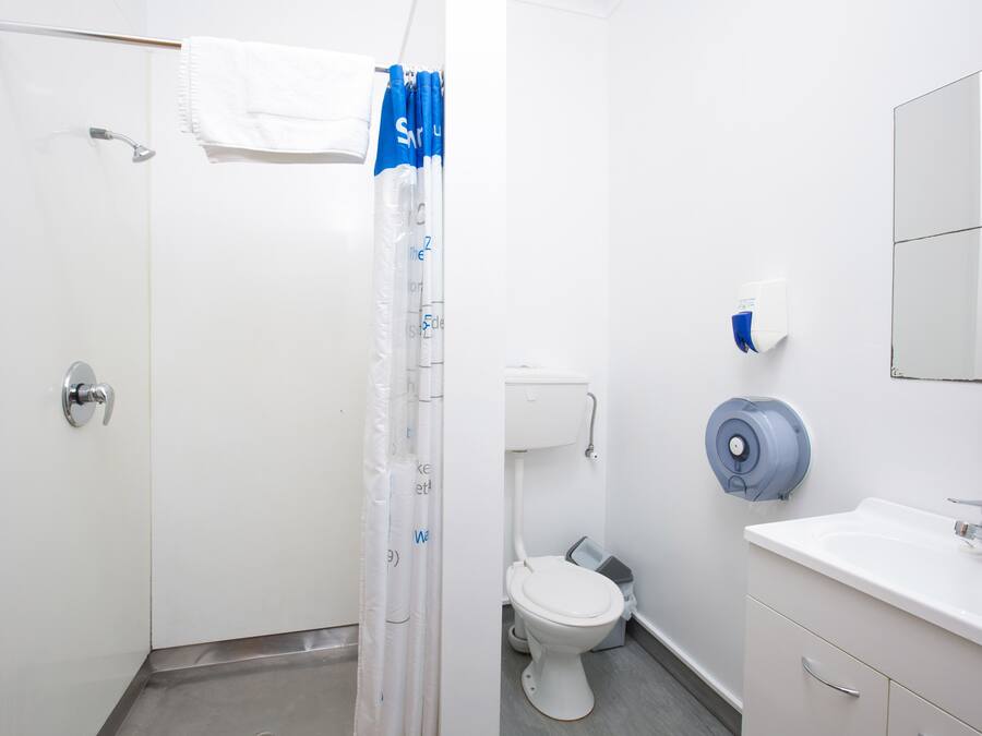 Ein Badezimmer mit Dusche, Toilette und Waschbecken.