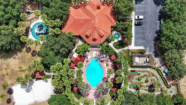 Vista aérea de um resort com uma piscina central, várias piscinas menores e paisagismo exuberante.