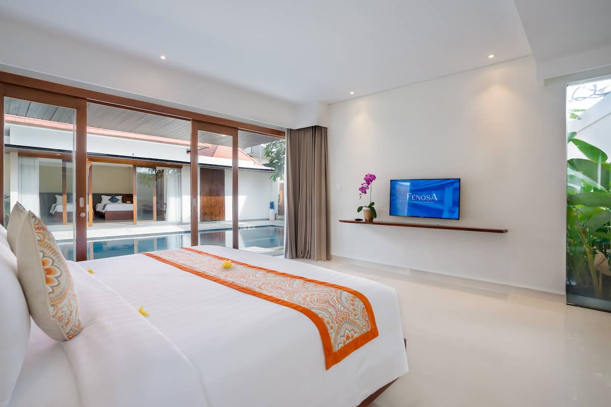Une chambre d’hôtel moderne avec un grand lit, une télévision et une vue sur une piscine.
