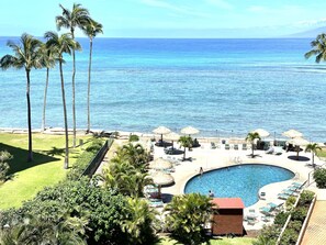 Ein Resort mit Pool, Liegestühlen und Palmen.