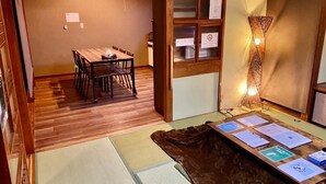 Una stanza tradizionale giapponese con pavimento in tatami, un tavolo di legno e una lampada.