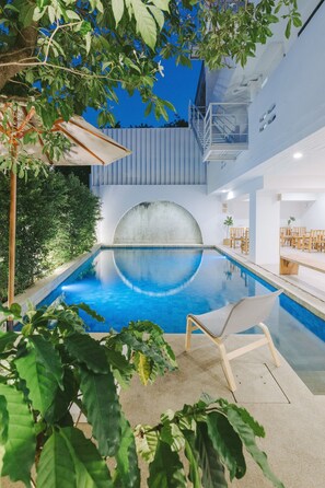 An indoor swimming pool with a clear blue water surface, surrounded by greenery and modern architectural elements. - Bedline Hotel (Phuket)