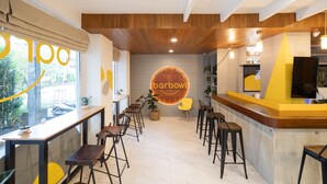 Een restaurantinterieur met een bar, houten plafond en een 'barbowl' bord.