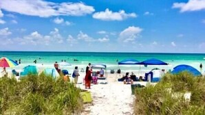 Une plage avec des parasols et des gens.