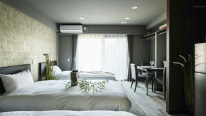A modern hotel room with two beds, a dining area, and a large window with curtains. - Vacation Rent Kanazawa (Kanazawa)