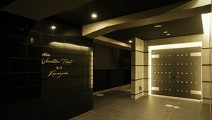 A modern hotel lobby with a reception desk, a private elevator, and a sign indicating "Hotel Vacation Rental." - Vacation Rent Kanazawa (Kanazawa)