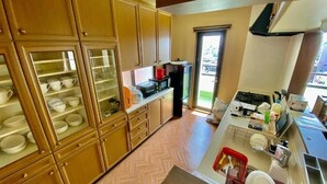 Suite Deluks | Dapur pribadi | Lemari es, ketel listrik, kursi makan untuk bayi, dan meja makan