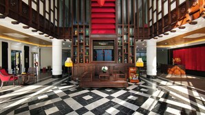 A lobby with a checkered floor, wooden columns, and a staircase with red steps. - Silkian Hoian Boutique Hotel & Spa (Da Nang)