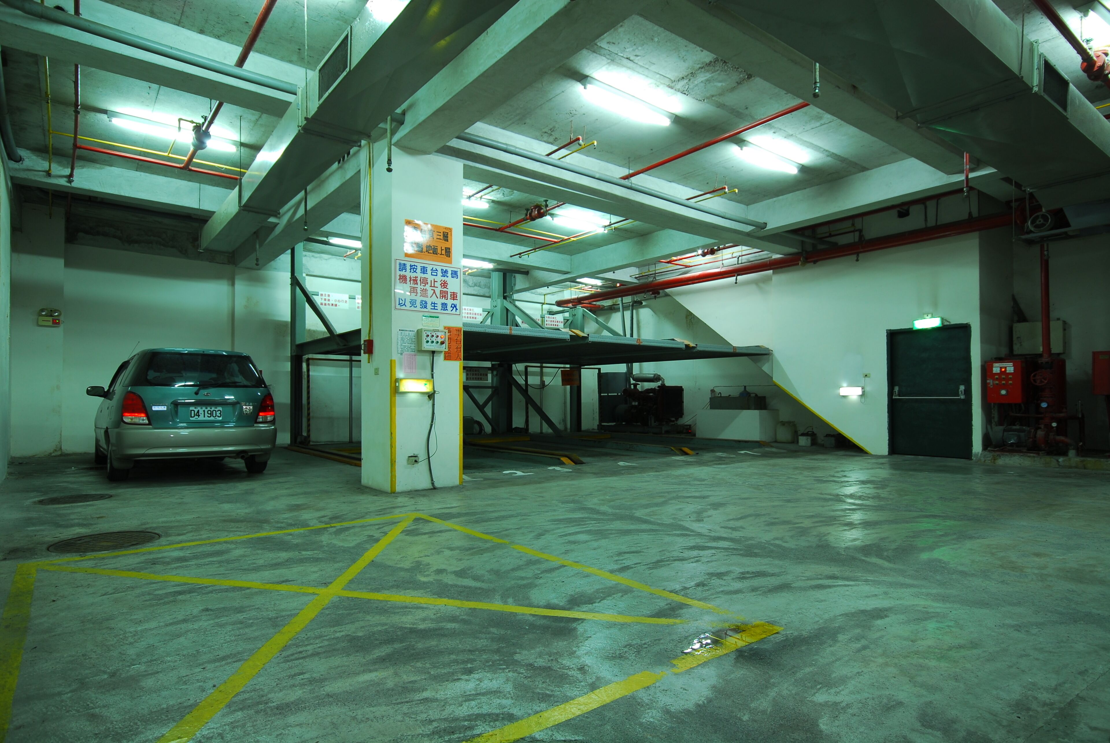 A parking garage with a car parked in a marked space.