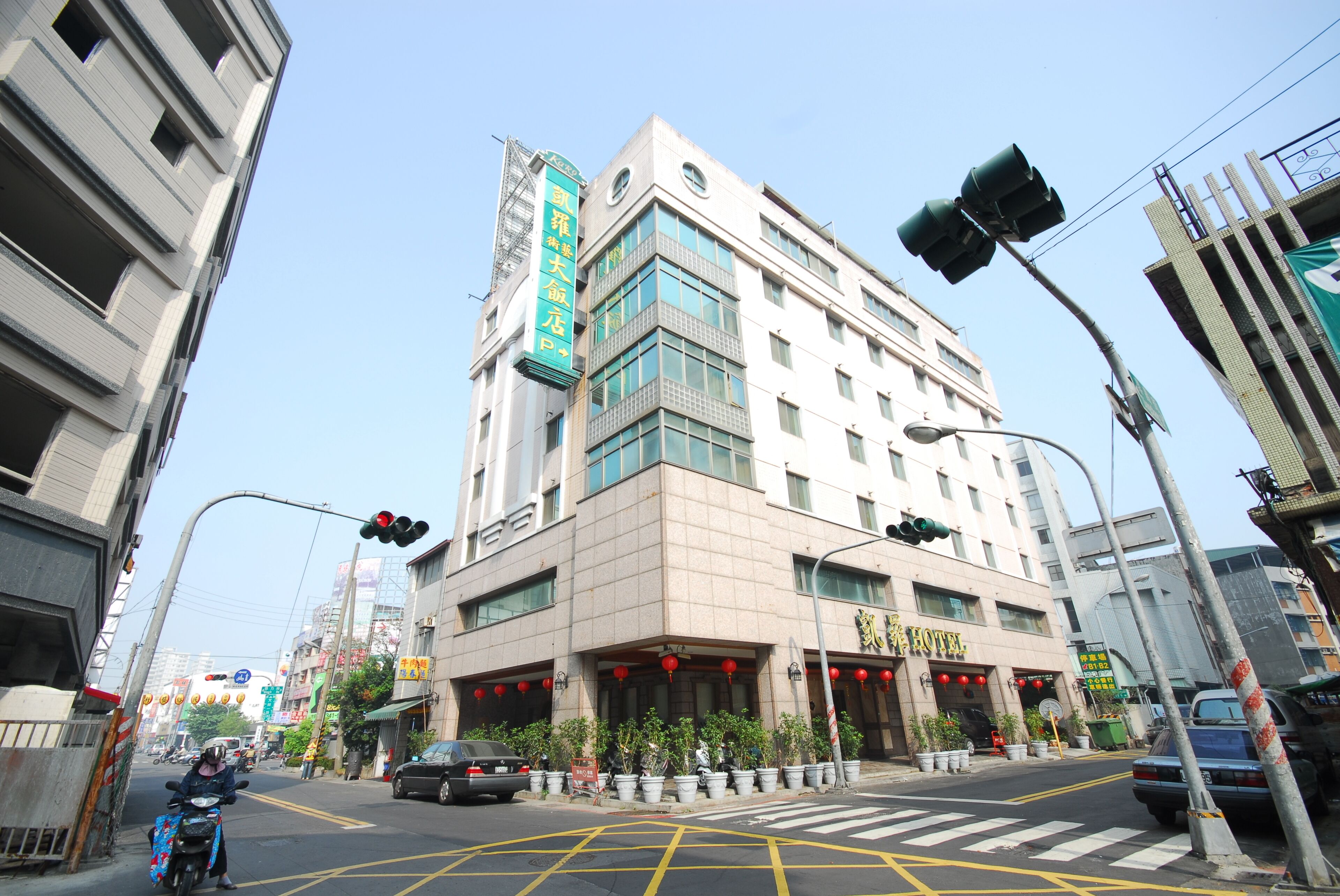 A hotel with a modern design, featuring a prominent entrance with red lanterns and a signboard.