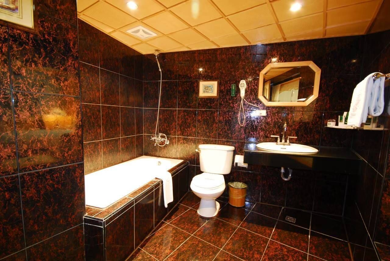 Uma casa de banho moderna com banheira, sanita e lavatório.