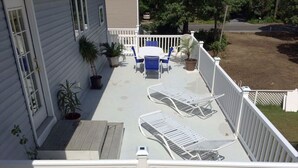 A deck with a table and chairs, surrounded by potted plants and a white fence. - NEW! Steps to DE Bay BEACH & Parks, Short Ride Cape May, Wildwood, Stone Harbor! (Cape May Beach)