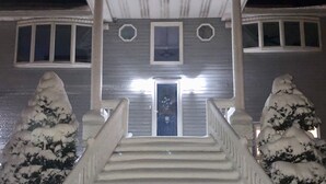 A house with a front porch, a staircase, and snow-covered trees. - NEW! Steps to DE Bay BEACH & Parks, Short Ride Cape May, Wildwood, Stone Harbor! (Cape May Beach)