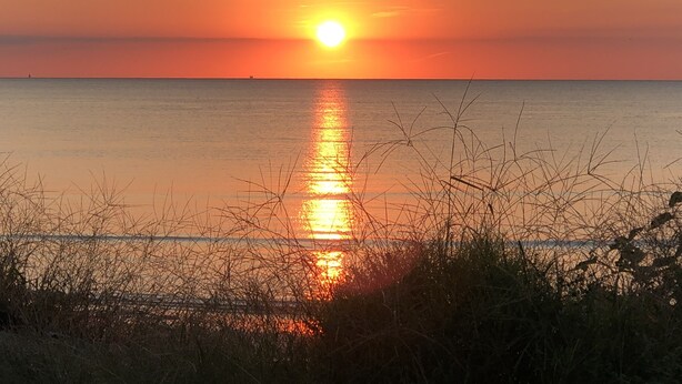 A sunset over a calm sea with a clear horizon. - NEW! Steps to DE Bay BEACH & Parks, Short Ride Cape May, Wildwood, Stone Harbor! (Cape May Beach)