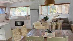 A modern kitchen with white cabinetry, a built-in oven, and a refrigerator.
