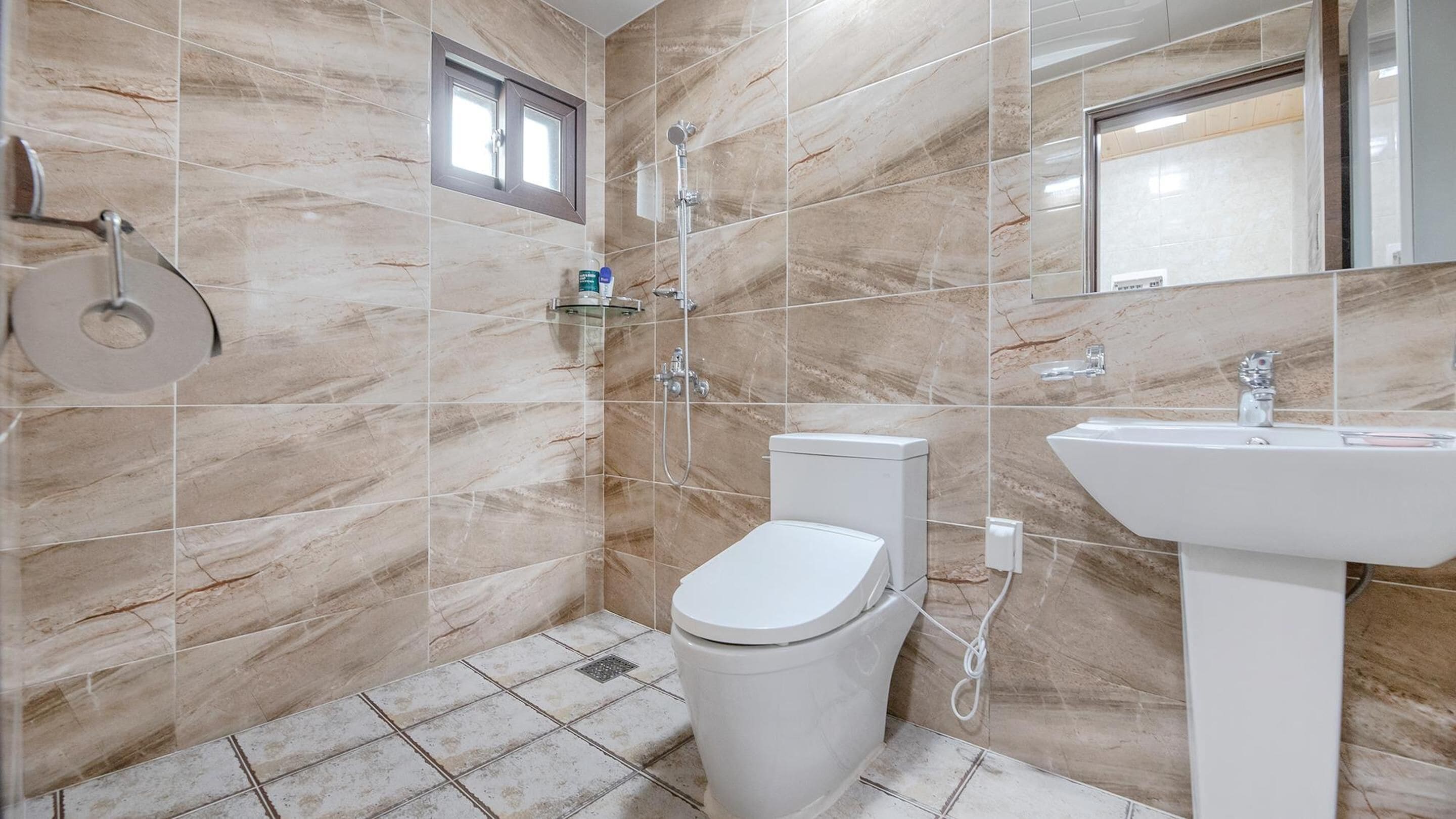 Een badkamer met toilet, bidet en wastafel, alles in het wit.