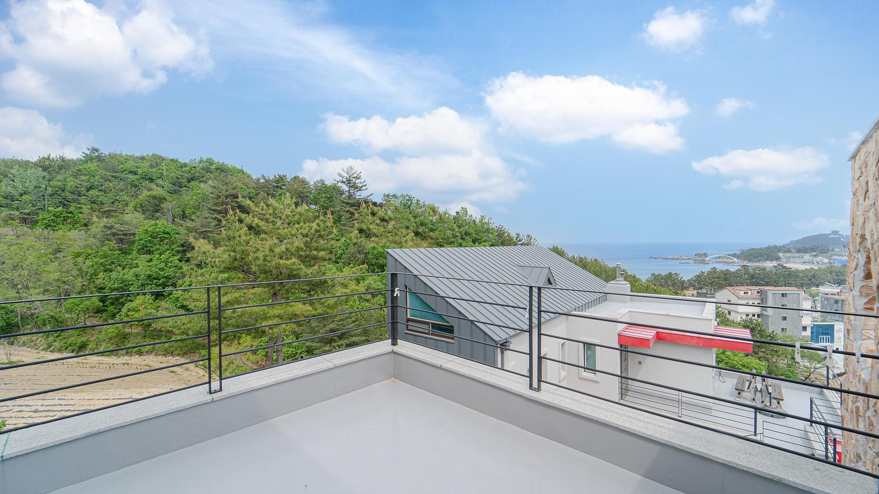 Une terrasse sur le toit offrant une vue sur la mer et la verdure.