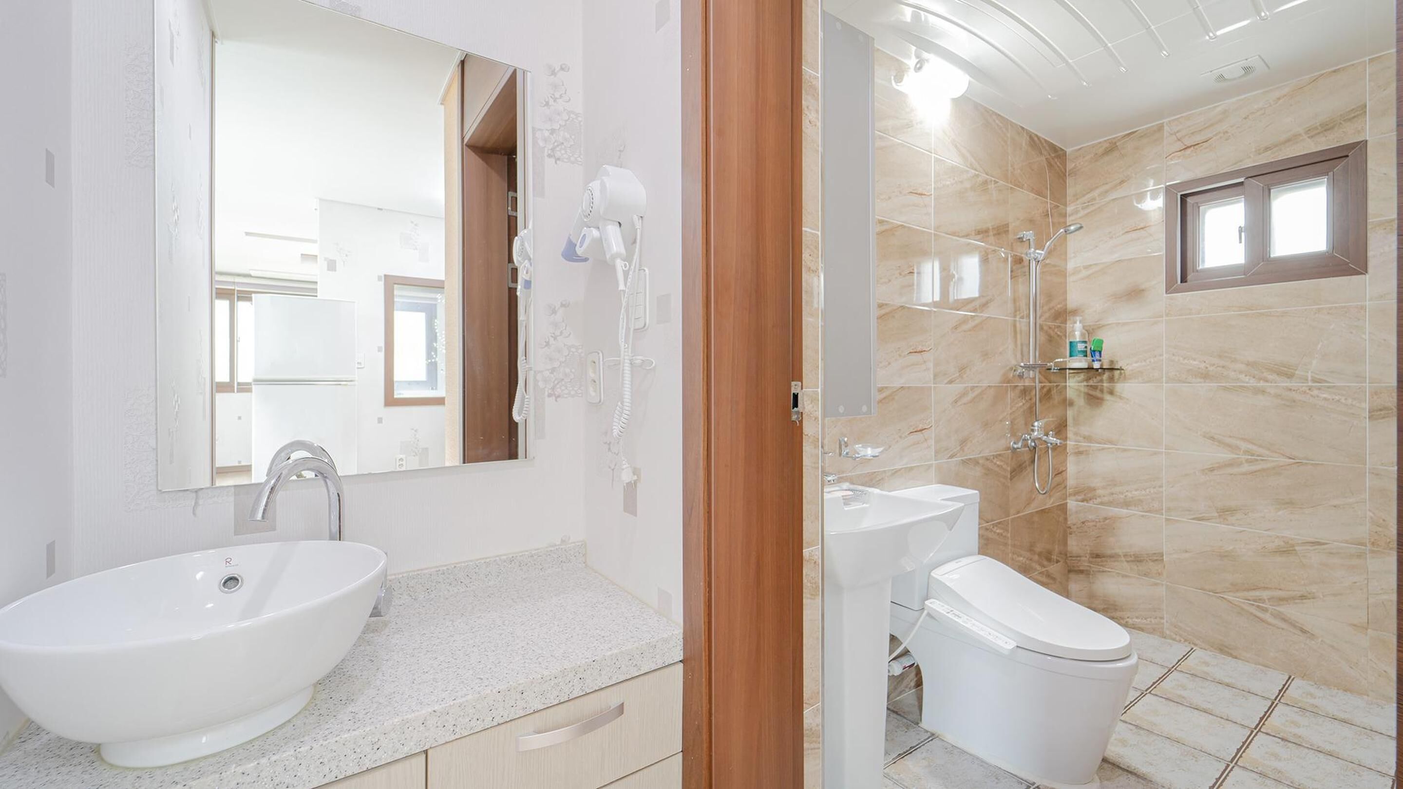 A modern bathroom with a freestanding bathtub, a standard sink, and a toilet.