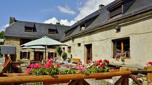 A stone building with a balcony and outdoor seating area. - Gites for 15 people in the Pyrenees, 250m², Loudenvielle (Loudenvielle)