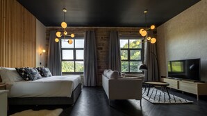 A modern bedroom with a bed, sofa, TV, and large windows. - Bowers Mill Aparthotel (Halifax)