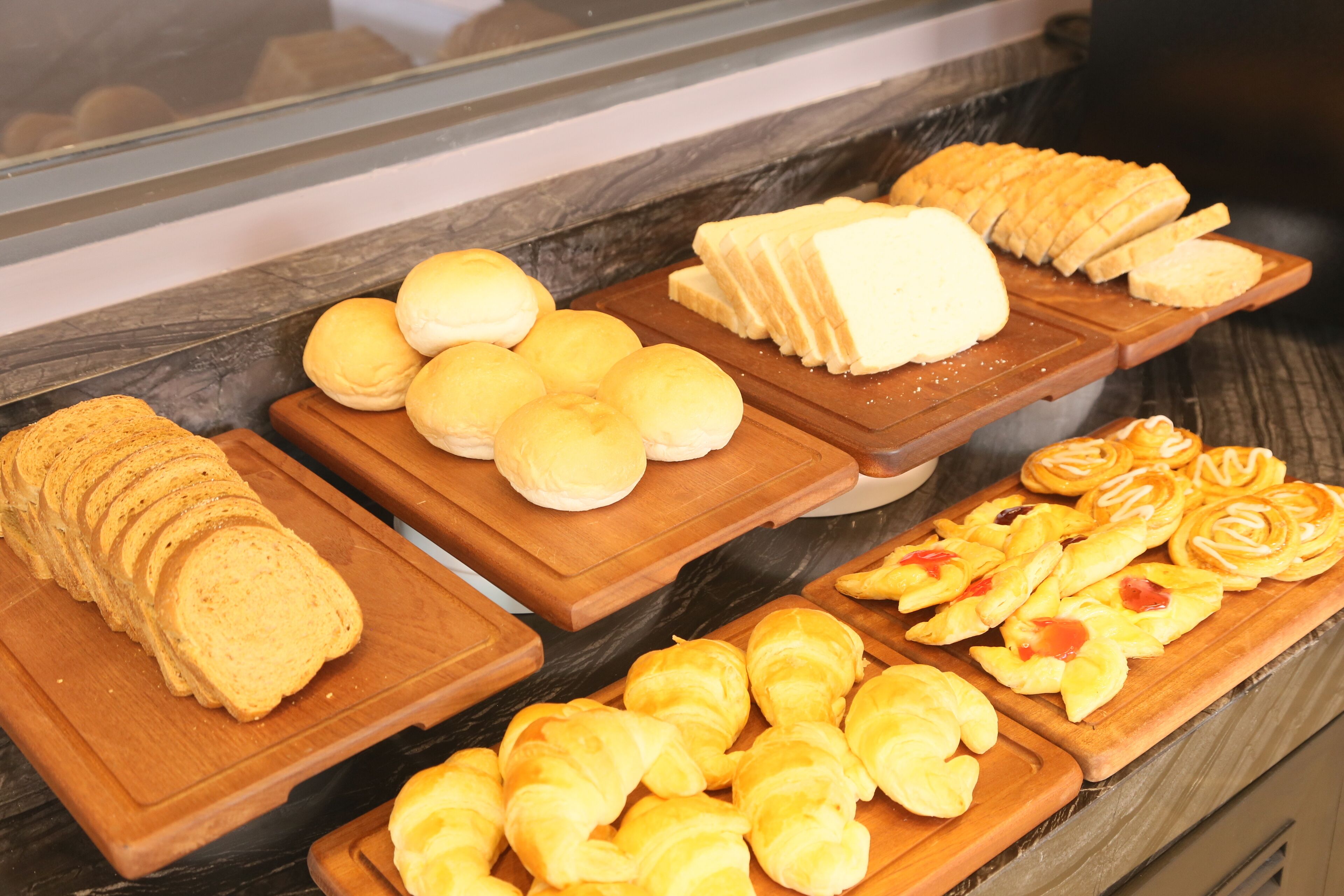 A display of various baked goods including bread, rolls, and pastries.