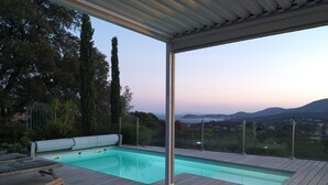 A wooden deck with a pool, outdoor furniture, and a view of the landscape. - 1st level villa overlooking the sea and the village - 300m from shops and restaurants (La Croix-Valmer)